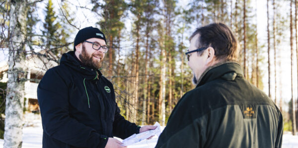 Metsänomistaja ja hankintaesimies metsässä.